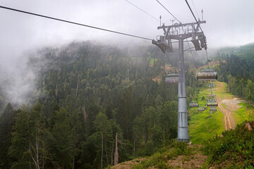 Fototapeta premium Chairlift in a mountain region in summer. Life of ski resort in summertime