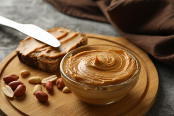 Concept of tasty breakfast with peanut and peanut butter on gray table