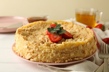 Concept of tasty lunch with plate of Napoleon cake on white wooden background