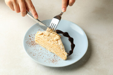 Woman eating delicious Napoleon cake, close up