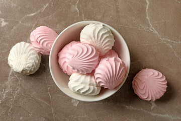 Bowl with sweet marshmallow on gray table