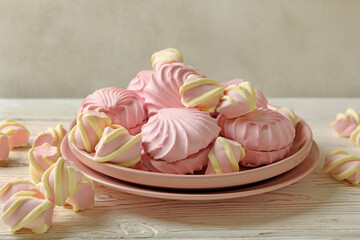 Plate with sweet marshmallow on wooden background