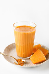 Glass of tasty pumpkin smoothie on white background