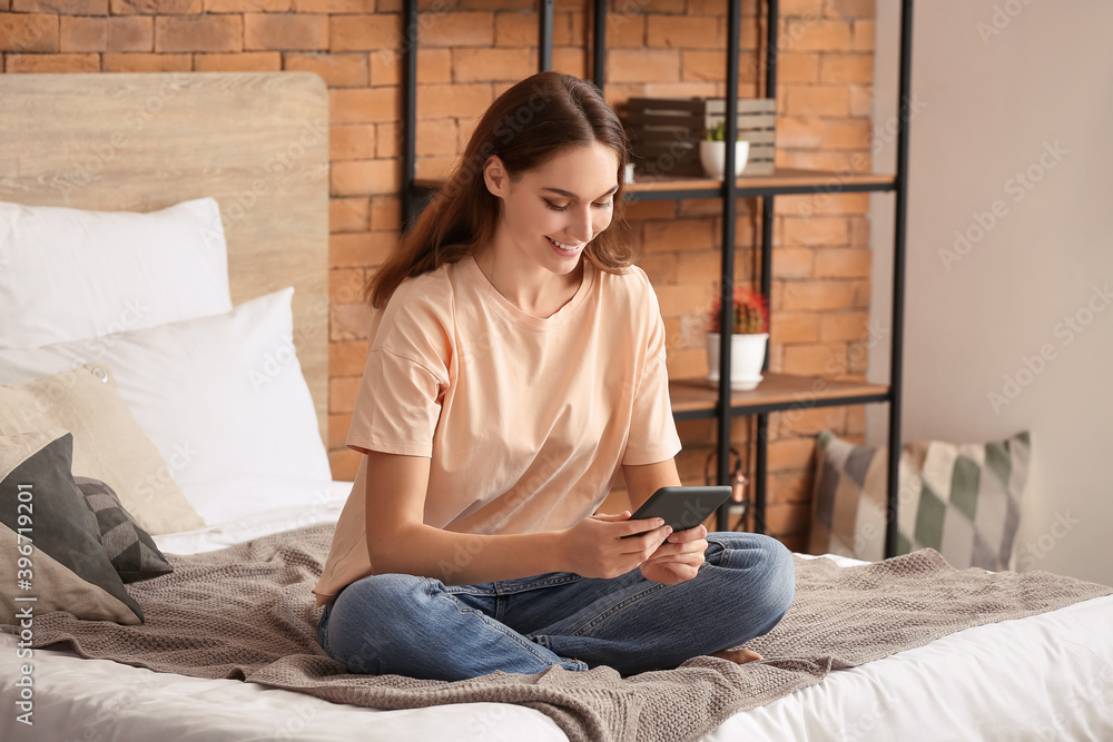 Poster Beautiful young woman reading e-book at home