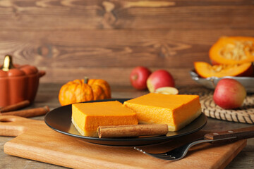 Plate with pieces of tasty pumpkin pie on table