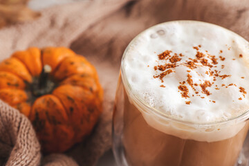 Obraz na płótnie Canvas Cup of pumpkin cappuccino on table, closeup