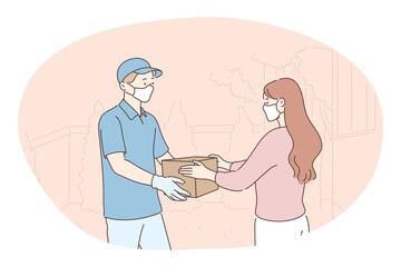 Contactless delivery, courier, online order concept. Young man courier deliveryman in protective medical mask and gloves giving order in box to woman customer. Parcel, logistics during pandemic 