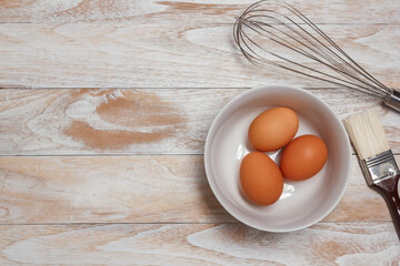 Homemade  Recipe Eggs,and wooden kneading dough on a wooden table, view from above