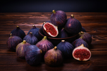 Tasty figs in a bowl on wooden background. Top view.