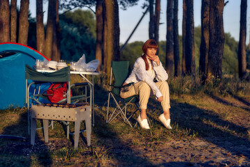 Stop for tourists at sunset in a pine forest. Summer outdoor recreation. Tourist trip. woman in nature