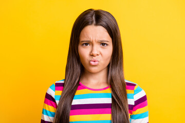 Fototapeta premium Photo of displeased dissatisfied small girl frowning face wear striped shirt isolated yellow color background