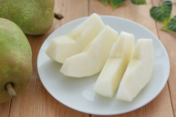 白い皿に盛りつけた洋梨