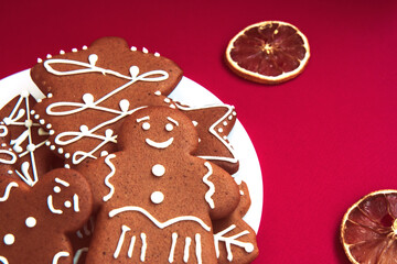 Homemade Christmas gingerbread and dried lemon slices on a bright red background. Merry Christmas