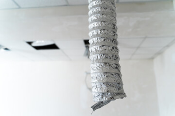 Air ventilating tube in building hanging from the ceiling. Aluminium air conditioning tube.