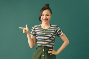 Cute young woman points a finger away