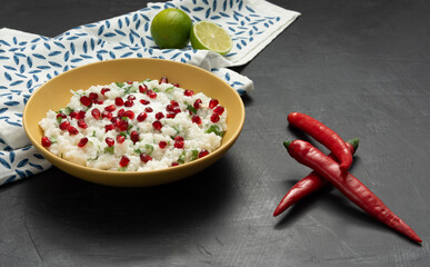 Curd cheese in a yellow plate on a dark background. Lime, hot red pepper.