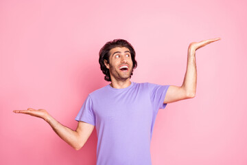 Photo of nice cheerful person comparing two versions palm empty space magenta t-shirt isolated on pink color background