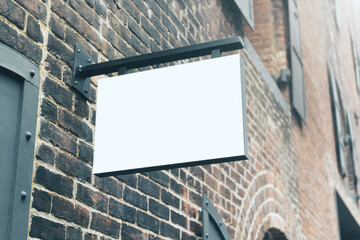 White blank signboard hanging on brick wall, mockup