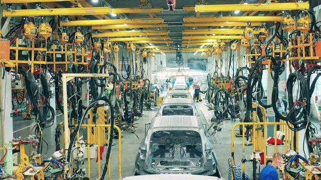 Industrial factory interior. Cars are getting manufactured in the factory unit