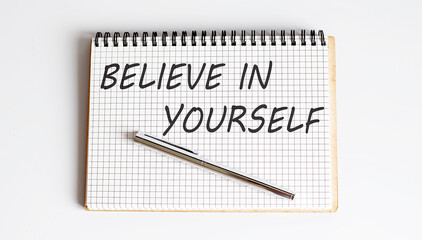 Believe in yourself text on the notepad with pen