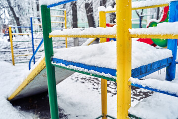 The children's slide is covered with the first snow.