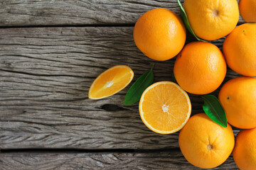 fresh orange fruits with leaves on wooden table.