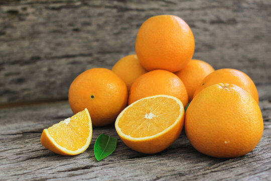 fresh orange fruits with leaves on wooden table. © Smile Studio AP