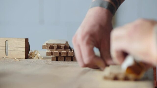 the carpenter grinds the grooves in the wood with sandpaper for further gluing to the dovetail joint. carpentry concept