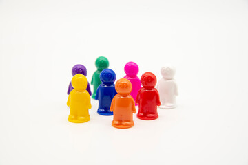Board game colorful plastic figures stand in a crowd on a light background.