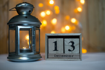 Cube wooden calendar showing date on 13th December with advent lantern over bokeh background. Advent calendar, Christmas background, Copy space