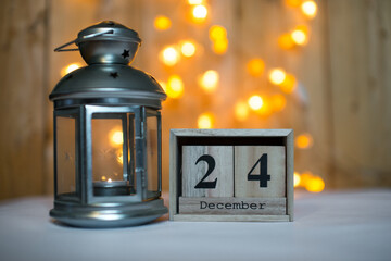 Cube wooden calendar showing date on 24th December with advent lantern over bokeh background. Advent calendar, Christmas background, Copy space