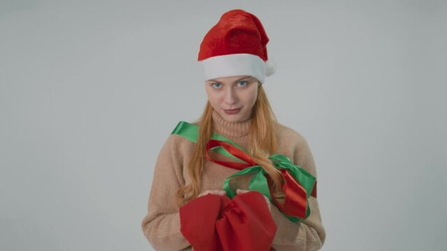 Santa Claus girl in Xmas outfit with a red sack. Wish and holidays concept.