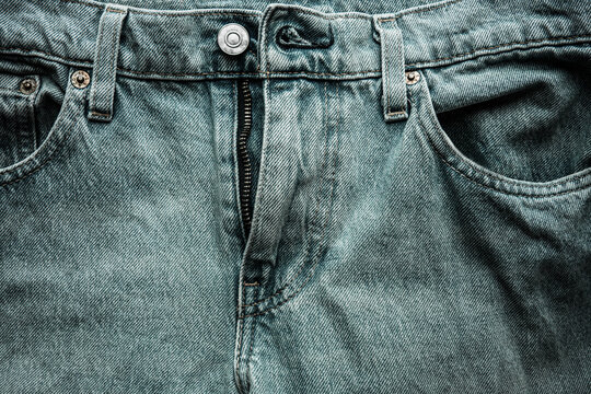 Denim blue jeans button and zip close-up. Casual jeans clothing in demin material, photographed in studio with low-key illumination.