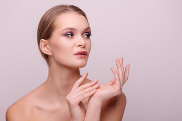 Fototapeta na wymiar Beautiful portrait of a young girl. Beauty industry beauty salon. Evening make-up. Bare shoulders. Glamorous woman elegant hands. Healthy skin, no acne. Medical procedures cosmetology. copyspace