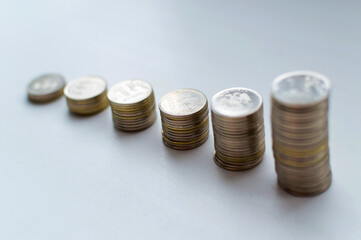Increasing columns of coins, looks like as growth chart, step of stacks coin isolated on white background with copy space for business and financial concept idea.