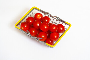 Red cherry tomatoes in a basket, isolated on a white background