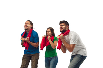 Hopeful. Three soccer fans woman and men cheering for favourite sport team with bright emotions isolated on white studio background. Looking excited, supporting. Concept of sport, fun, support.