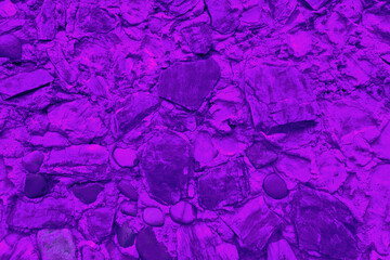Abstract background of many large stones. The empty stone surface is purple in color.
