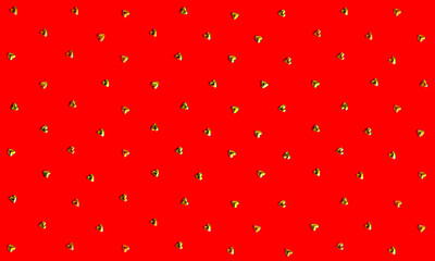 Pattern. Gold hearts on a red background. Photo taken with selective focus and has a noise effect
