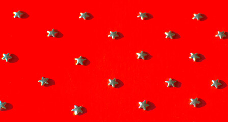 Silver stars on a red background. Photo taken with selective focus and noise effect