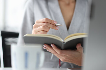 Woman holds pen and an open diary concept