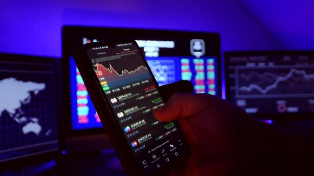 Stock market trader working on smartphone on stockmarket. Man is  scrolling through foreign exchange market data, chart and forex news.