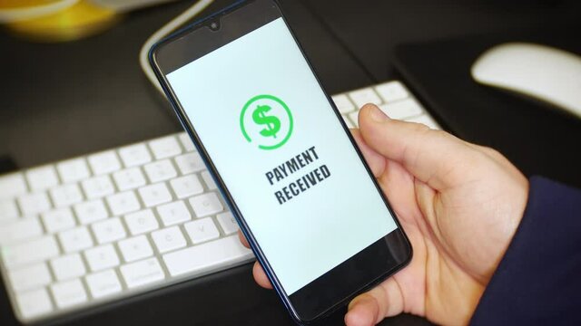 A payment received notification is received on a payment app on a cell phone. The mobile application displays a dollar sign to represent money being received.