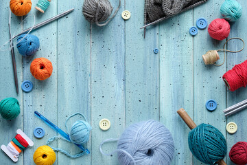 Decorative frame made of wool bundles, yarn balls, buttons and cord. Latch and knitting needles....