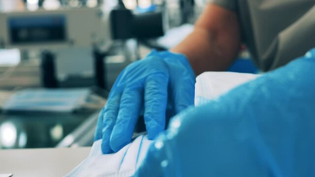 Face masks being stacked on the table by a medical worker. Close up