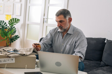 Fototapeta premium middle aged man shopping online from his home
