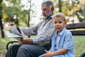 Fototapeta na wymiar grandfather and his grandson spending time together in public park