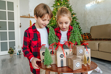 Children opening Christmas handmade advent calendar box