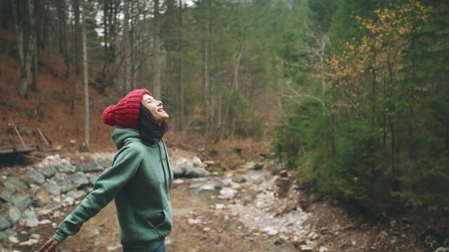Close-up of asian girl inhaling deeply and spreading arms wide. Woman meditating in front of mountain landscapes. Female feeling freedom and happiness. Outdoor activities after trekking or hiking.