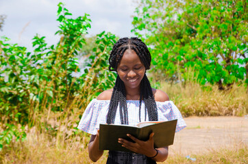 Fototapeta premium a young beautiful african school student feeling excited as she is going through her notebook